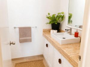 a bathroom with a sink and a mirror at Hermoso apartamento en Manzanillo con alberca y cancha de tenis, Ideal para relajarse y disfrutar de una escapada tranquila en el paraíso tropical in Manzanillo +28 photos