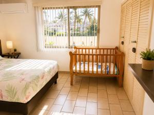 a bedroom with a crib in front of a window at Hermoso apartamento en Manzanillo con alberca y cancha de tenis, Ideal para relajarse y disfrutar de una escapada tranquila en el paraíso tropical in Manzanillo