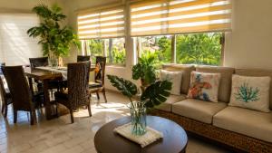 a living room with a couch and a table at Hermoso apartamento en Manzanillo con alberca y cancha de tenis, Ideal para relajarse y disfrutar de una escapada tranquila en el paraíso tropical in Manzanillo