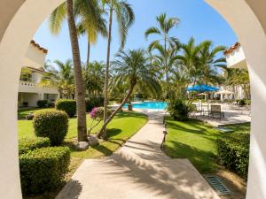 a view of the pool from the balcony of a resort at Hermoso apartamento en Manzanillo con alberca y cancha de tenis, Ideal para relajarse y disfrutar de una escapada tranquila en el paraíso tropical in Manzanillo
