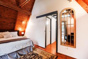 a bedroom with a bed and a mirror at Family & Friends Cottage in Mount Tamborine