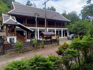 a large wooden building with a porch at Le Charme Pakbeng Villa in Pakbeng