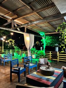 a patio with blue and green chairs and a table at Pousada Anturio in Barra Velha