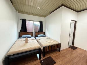 a bedroom with two beds and a window at ปิล๊อกพอเพลิน-pilokporploen in Ban Pilok Khi