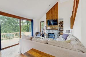 a living room with a large couch and a fireplace at Sleepless in Snowood in Thornton