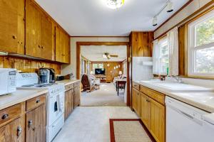 a kitchen with wooden cabinets and a white stove top oven at Seaside Cottage in Wells