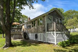 a small house with a porch and a tree at Seaside Cottage in Wells