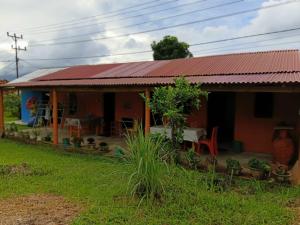 a small house with a red roof and a yard at Wale Chika Guest House in Tomohon