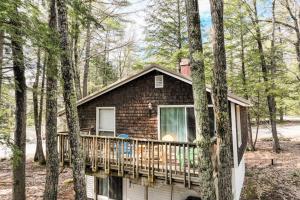 a house with a deck in the woods at The Good Knight in Bridgton