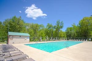 a swimming pool with chairs and a building at The Good Knight in Bridgton