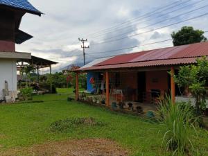 a house with a red roof and a yard at Wale Chika Guest House in Tomohon