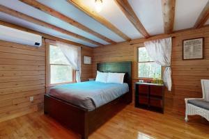 a bedroom with a bed in a room with wooden walls at Charming Hideaway in Scarborough