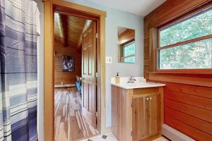 a bathroom with a sink and a wooden wall at Charming Hideaway in Scarborough +42 photos