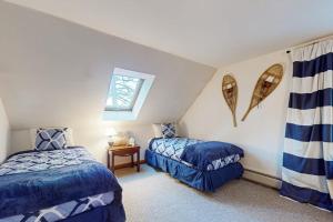 a attic room with two beds and a window at Moose Haven in Denmark