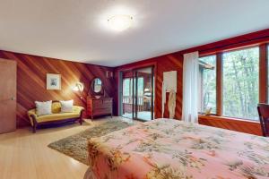 a bedroom with a bed and a couch and windows at Writer's Retreat in Wells