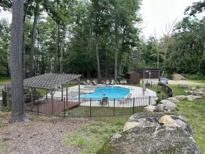 aenced in swimming pool in a yard with people around it at Snowy Peaks Hideaway in Conway