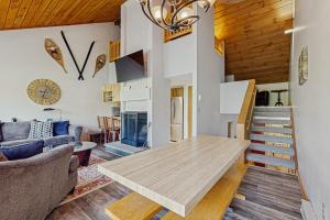 a living room with a wooden table and a staircase at Loon Mountain Nest in Lincoln