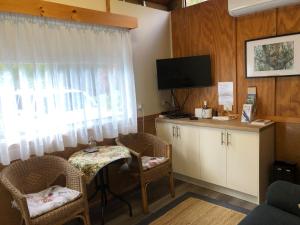 a living room with a table and chairs and a tv at Copeland Cabins in Copeland