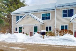 a house with snow in front of it at The Evergreens in North Conway