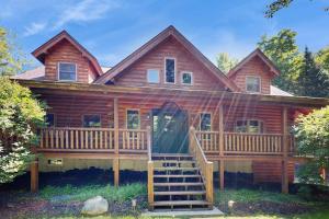 a log cabin with a large porch and a deck at The Den In Franconia in Franconia