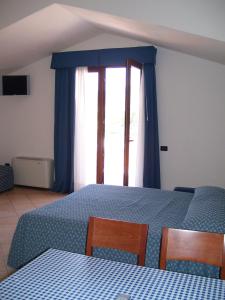 a bedroom with a blue bed and a window at Resort Isola Rossa in Bosa