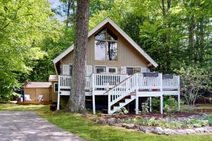 a small house with a porch and a tree at The Beech Cottage in Tuftonboro