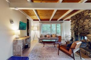 a living room with a couch and a stone fireplace at The Beech Cottage in Tuftonboro