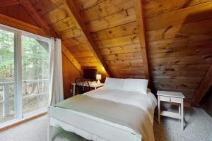a bedroom with a bed in a wooden cabin at The Beech Cottage in Tuftonboro