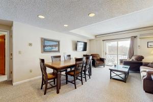 a living room with a wooden table and chairs at Sunset Peak at Rivergreen in Lincoln