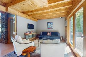 a living room with a blue couch and white chairs at Bearly Behaving Lodge in Sugar Hill
