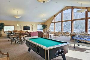 a room with a pool table and tables and chairs at Sunset Peak Condo at Rivergreen in Lincoln