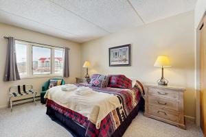 a bedroom with a bed and a chair and a window at Sunset Peak Condo at Rivergreen in Lincoln +58 photos