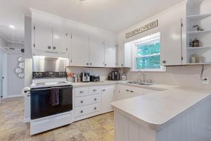 a kitchen with white cabinets and a stove top oven at Naples Hideaway Retreat in Naples