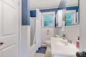 a white bathroom with a toilet and a sink at Naples Hideaway Retreat in Naples +42 photos