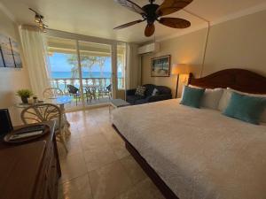 a bedroom with a bed and a view of the ocean at Oceanfront Studio at Islander on the Beach #325 in Kapaa