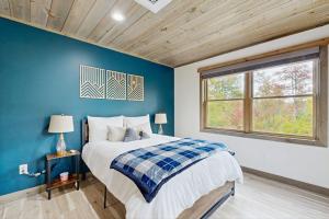 a bedroom with a bed and a blue wall at Brightwind Lodge in Bethel