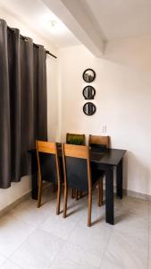 a dining room with a black table and chairs at Departamentos Aurora in Tuxtla Gutiérrez +7 photos
