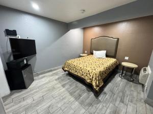 a bedroom with a bed and a flat screen tv at Motel 66 Los Angeles in Los Angeles