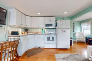 a kitchen with white cabinets and a white refrigerator at Hampton Beach Hangout in Hampton
