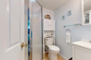 a white bathroom with a toilet and a shower at Hampton Beach Hangout in Hampton