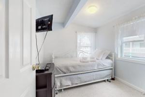 a white bedroom with a bed and a window at Hampton Beach Hangout in Hampton