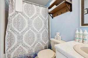 a bathroom with a shower curtain and a toilet at Beachfront Memories in Old Orchard Beach +56 photos