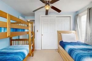 a bedroom with two bunk beds and a ceiling fan at Beachfront Memories in Old Orchard Beach
