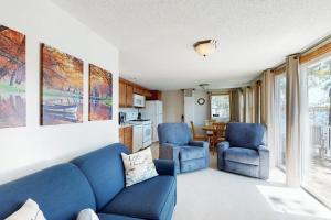 a living room with a blue couch and two chairs at Bayside Sunshine in Ossipee