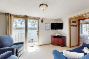 a living room with a blue couch and a television at Bayside Sunshine in Ossipee