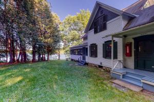 a white house with a porch and a yard at Garden Island's Birch in Charlotte