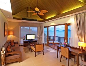 a living room with a ceiling fan and a dining room at The Sea View Residence in Ban Bang Bao