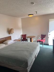 a hotel room with a bed and two chairs and a table at Townhouse Motel- Alhambra-South Pasadena-San Marino in Alhambra