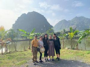 a group of people standing in front of a river at Tràng An Gold in Xuân Sơn