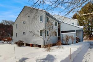 a white house with a garage in the snow at Brookhaven D4 in Ludlow